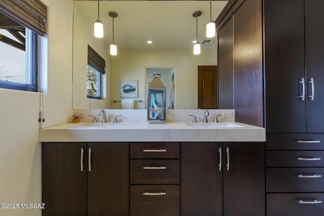 full bath featuring double vanity, visible vents, and a sink