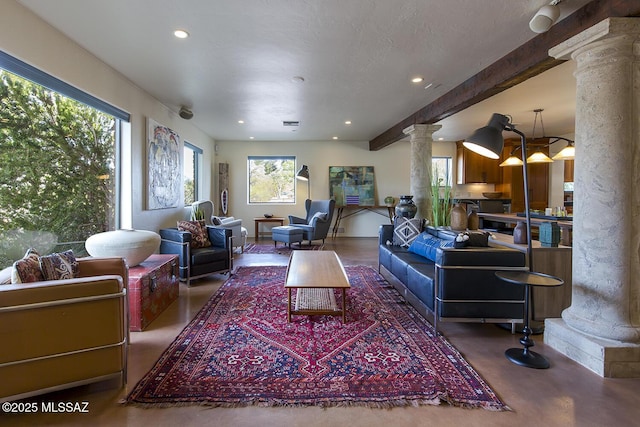 living area featuring decorative columns, beamed ceiling, finished concrete floors, a textured ceiling, and recessed lighting