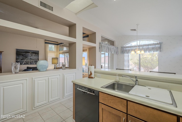 kitchen featuring pendant lighting, light tile patterned floors, sink, black dishwasher, and a notable chandelier