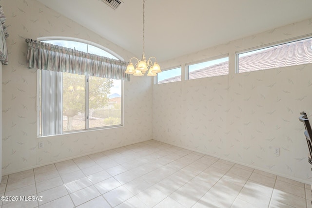 spare room with vaulted ceiling, light tile patterned floors, and a notable chandelier