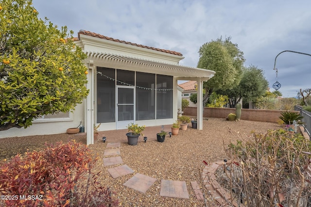 back of property with a pergola and a sunroom