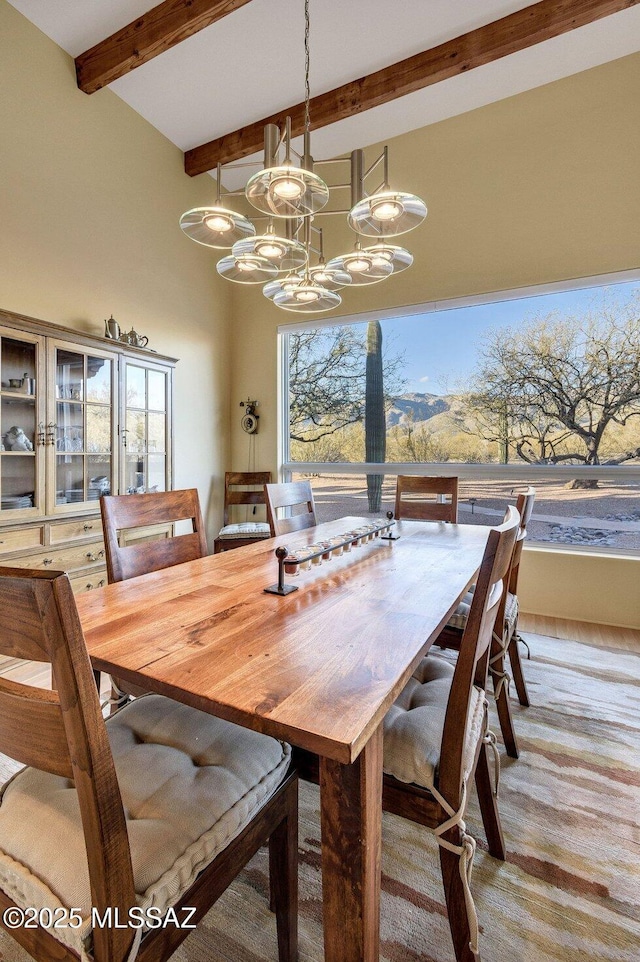 dining area with beamed ceiling and a notable chandelier