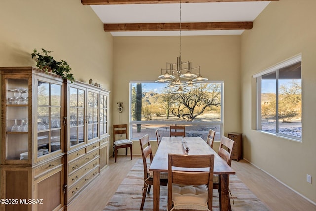 dining room featuring beamed ceiling, an inviting chandelier, and light wood-type flooring