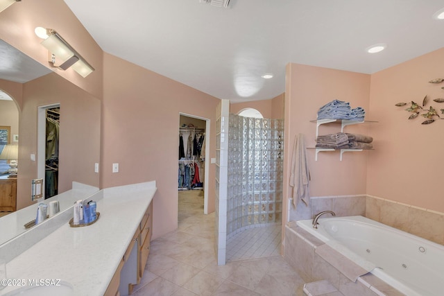 bathroom with vanity, tile patterned flooring, and plus walk in shower