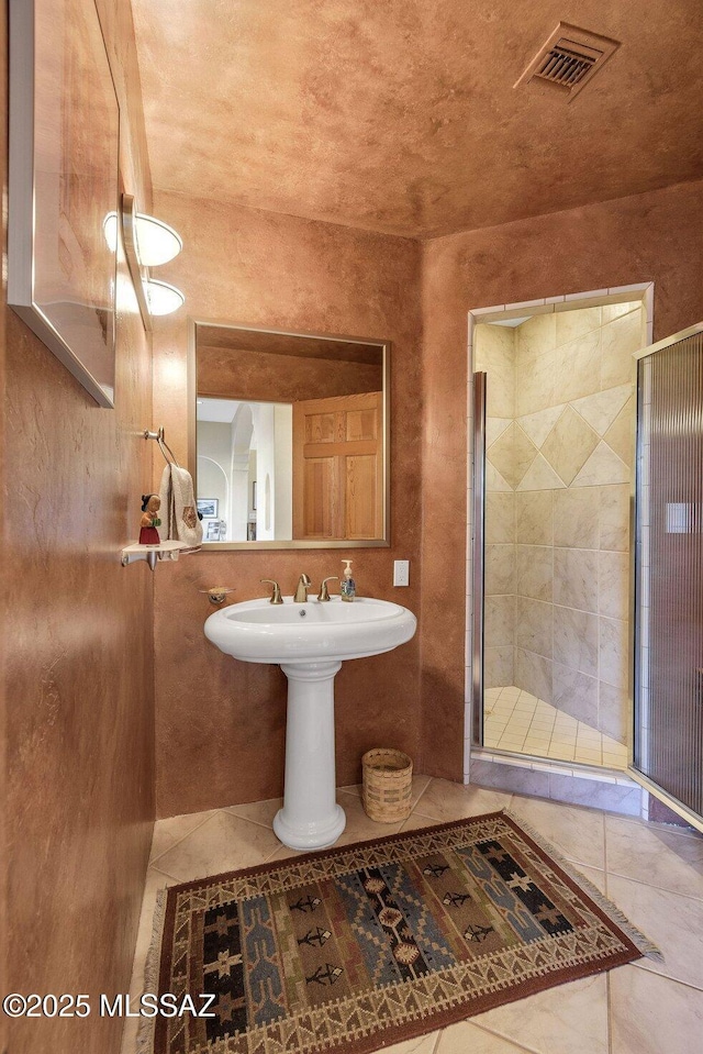 bathroom featuring tile patterned floors, an enclosed shower, and sink