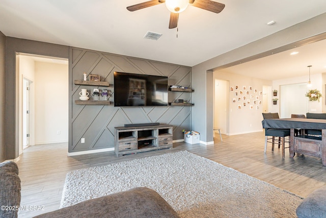 living room with ceiling fan and light hardwood / wood-style flooring