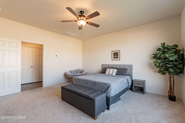 carpeted bedroom featuring ceiling fan and a closet