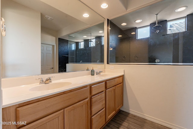 bathroom featuring tiled shower, vanity, and hardwood / wood-style floors