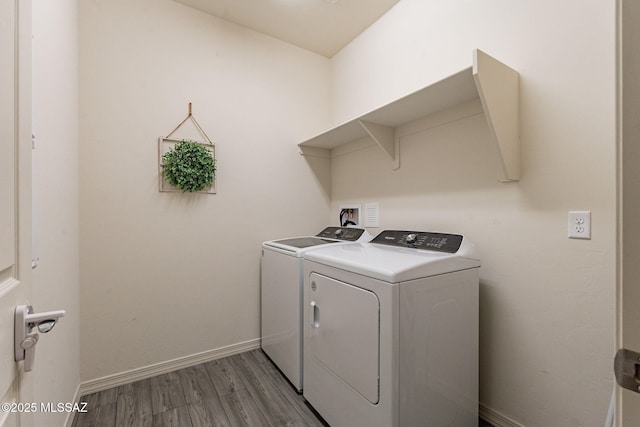 washroom with washing machine and dryer and hardwood / wood-style floors