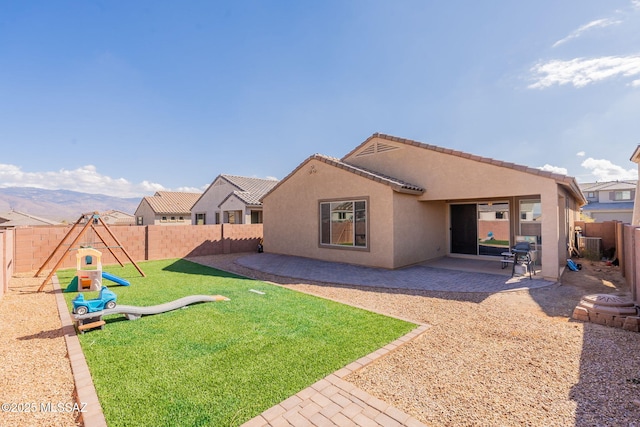 back of property featuring a playground, a lawn, central air condition unit, and a patio area