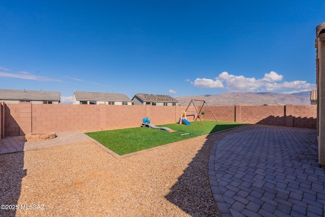 view of yard with a mountain view, a patio, and a playground