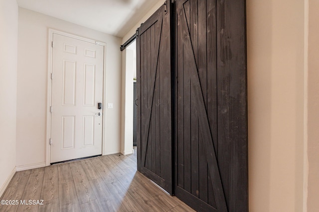 entrance foyer with light hardwood / wood-style flooring and a barn door