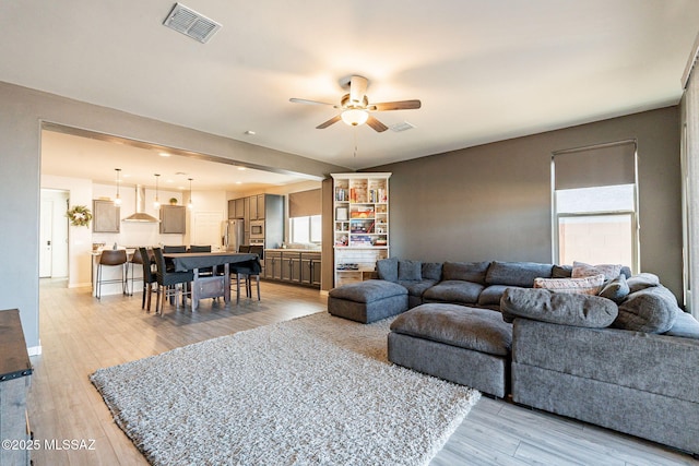 living room with ceiling fan and light hardwood / wood-style floors