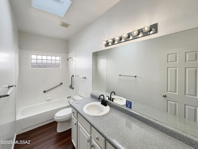 full bathroom with wood-type flooring, toilet,  shower combination, and vanity