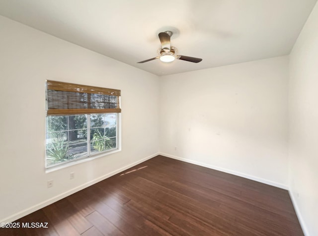 empty room with ceiling fan and dark hardwood / wood-style flooring