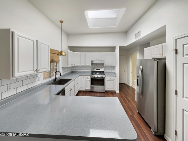 kitchen featuring sink, white cabinetry, hanging light fixtures, appliances with stainless steel finishes, and backsplash