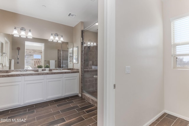 bathroom with tiled shower and vanity