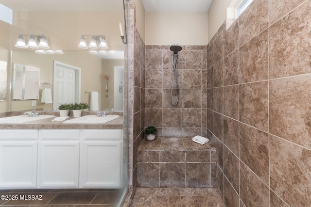 bathroom with vanity and a tile shower