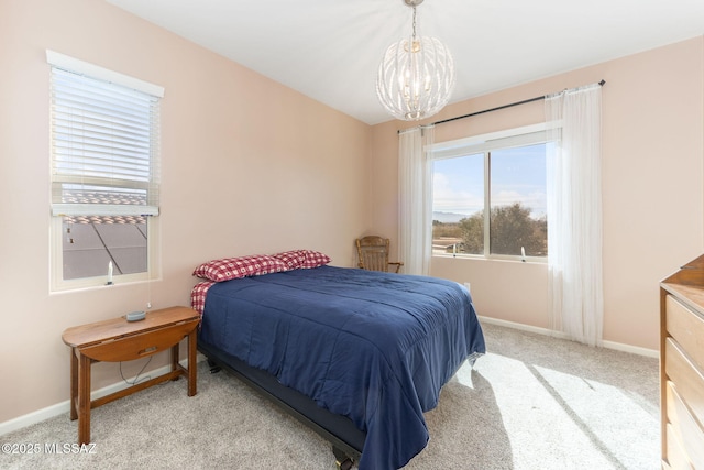 bedroom featuring light colored carpet and a notable chandelier