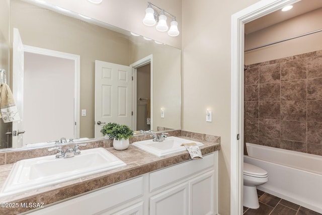 full bathroom with hardwood / wood-style flooring, vanity, toilet, and tiled shower / bath combo