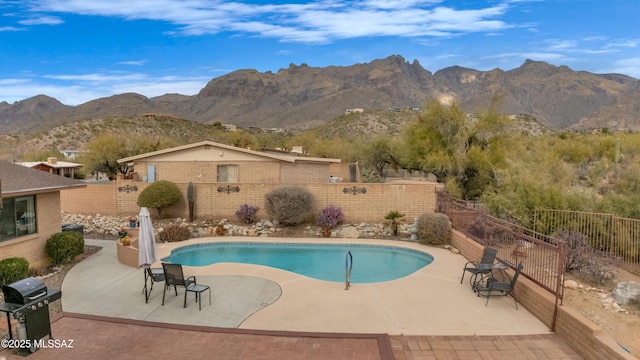 view of pool with a mountain view, a patio, and a grill