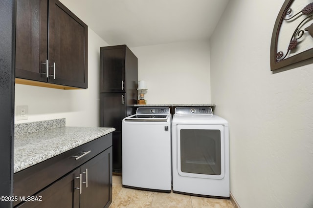 laundry room featuring washer and dryer and cabinets