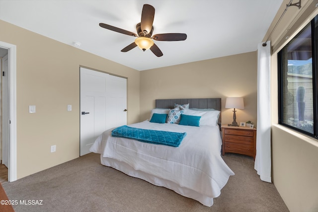 carpeted bedroom featuring ceiling fan and a closet