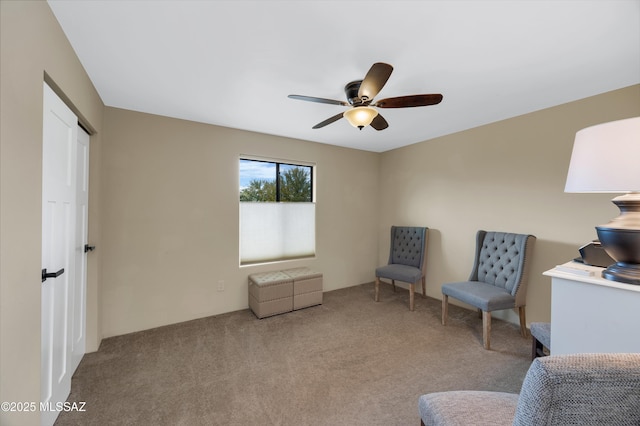 living area with ceiling fan and light colored carpet