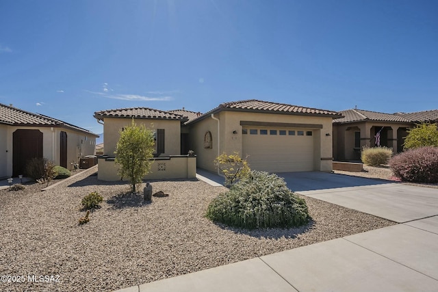 mediterranean / spanish-style house featuring a garage, a tiled roof, concrete driveway, and stucco siding