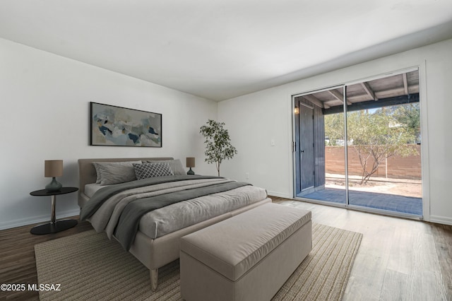bedroom with access to outside, baseboards, and wood finished floors