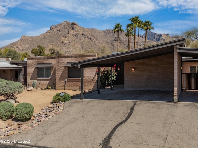 mid-century inspired home with an attached carport, driveway, and a mountain view