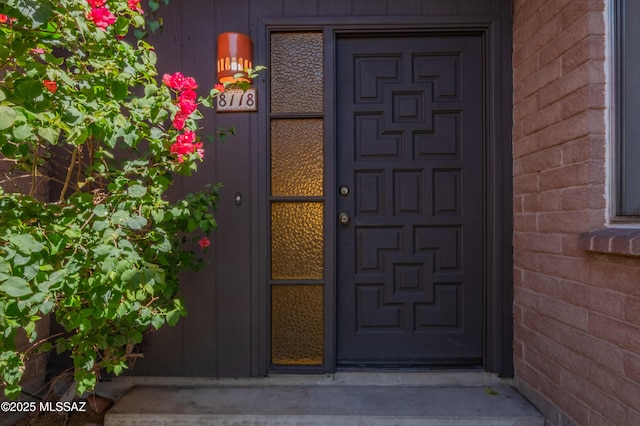 doorway to property with brick siding