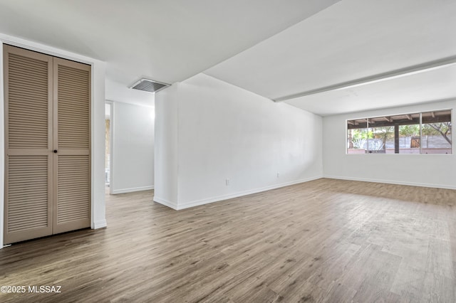 interior space featuring wood finished floors, baseboards, and visible vents