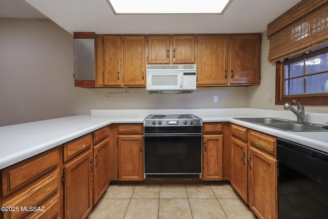 kitchen featuring dishwasher, range with electric cooktop, sink, and light tile patterned floors