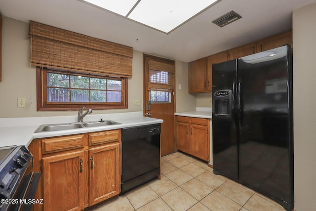 kitchen with light tile patterned floors, sink, and black appliances