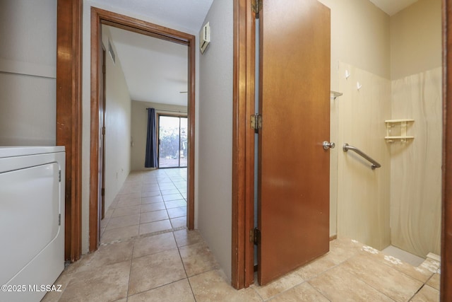 hallway featuring light tile patterned flooring and washer / dryer