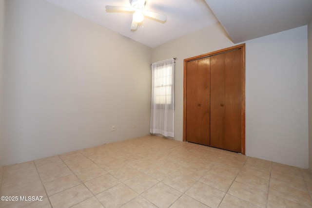 unfurnished bedroom with a closet, ceiling fan, and light tile patterned flooring