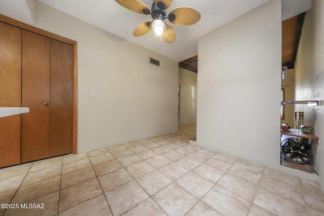 unfurnished bedroom with light tile patterned floors, ceiling fan, and a closet