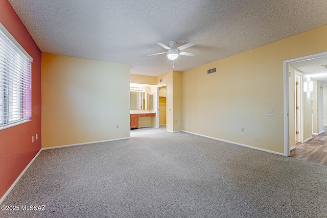 empty room with carpet floors, a textured ceiling, and ceiling fan