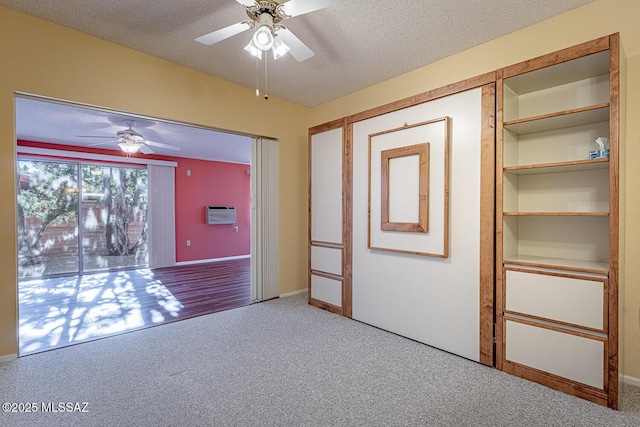 carpeted spare room featuring ceiling fan and a textured ceiling