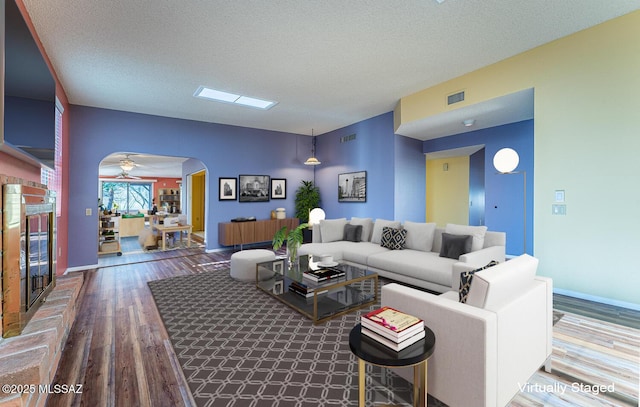 living room with wood-type flooring and a textured ceiling