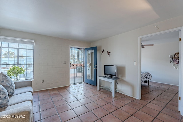 tiled living room with ceiling fan and a wealth of natural light