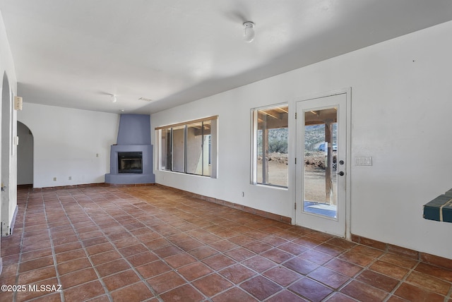 unfurnished living room featuring tile patterned flooring and a large fireplace