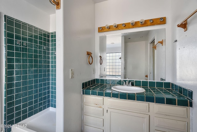 bathroom with vanity and tiled shower