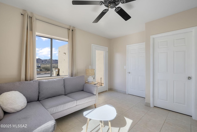 tiled living room featuring a mountain view and ceiling fan