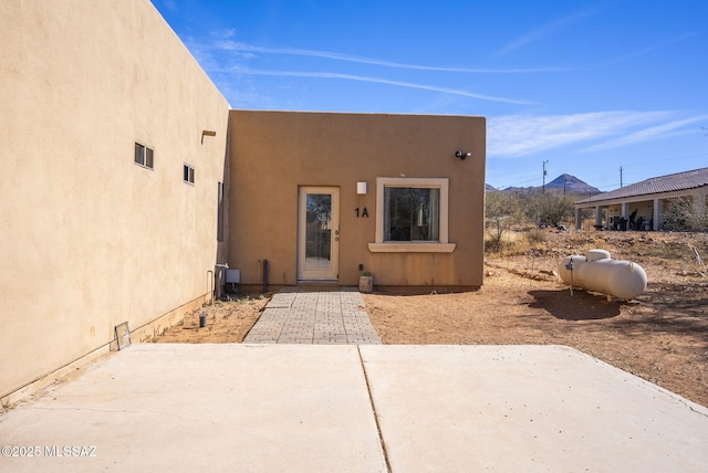 view of exterior entry with a patio area