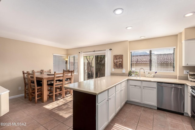 kitchen featuring a healthy amount of sunlight, white cabinetry, stainless steel appliances, and light countertops