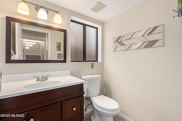 bathroom featuring toilet, baseboards, visible vents, and vanity