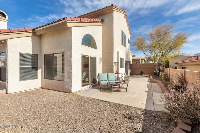 back of house featuring a patio area, a fenced backyard, a tiled roof, and stucco siding