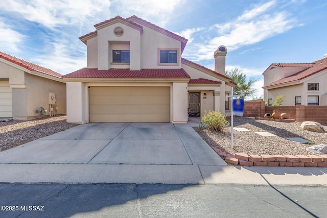 mediterranean / spanish house with concrete driveway, a tile roof, fence, and stucco siding